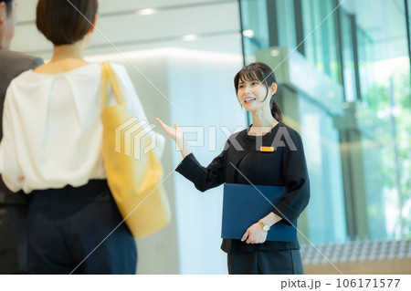 ミドルカップルを案内する受付の女性 106171577
