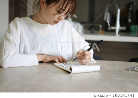 筆ペンで字を書く女性 106171741