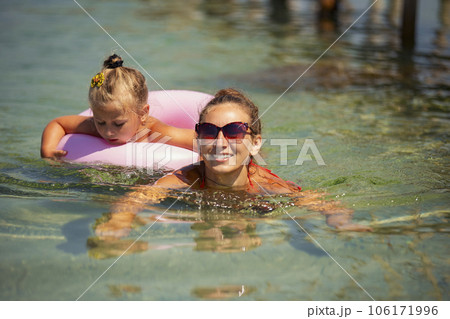 mother and daughter swimming in the sea mother and daughter swimming in the sea 106171996