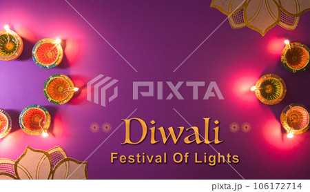 Happy Diwali - Clay Diya lamps lit during Dipavali, Hindu festival of lights celebration. Colorful traditional oil lamp diya on purple background Happy Diwali - Clay Diya lamps lit during Dipavali, Hindu festival of lights celebration. Colorful traditional oil lamp diya on purple background 106172714