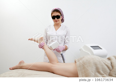 Woman prioritizes skin smoothness: laser leg hair procedure at luxury salon 106173634
