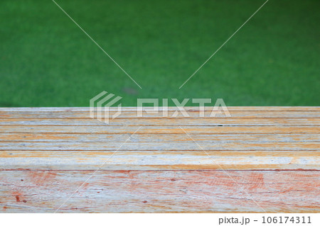 Old and pale of brown wood plank and green artificial grass. 106174311