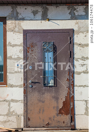 Old rusty iron door in an unfinished abandoned house Old rusty iron door in an unfinished abandoned house 106174478
