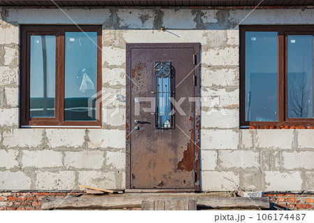 Old rusty iron door in an unfinished abandoned house 106174487