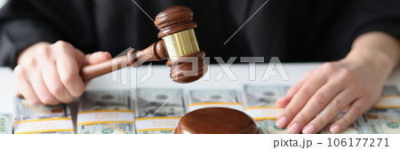 Judge with wooden gavel and a lot of dollar bills close-up. Judge with wooden gavel and a lot of dollar bills close-up. 106177271