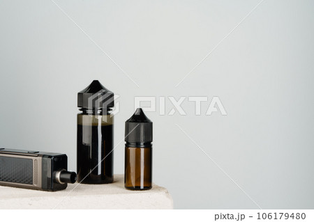 Vaping refill liquid bottle against gray background Vaping refill liquid bottle against gray background 106179480