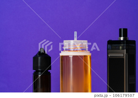 Electronic cigarettes liquid bottles on purple background 106179507
