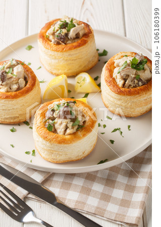 Vol au vent baked puff pastry with chicken, mushroom and cream closeup on the white wooden table. Vertical 106180399