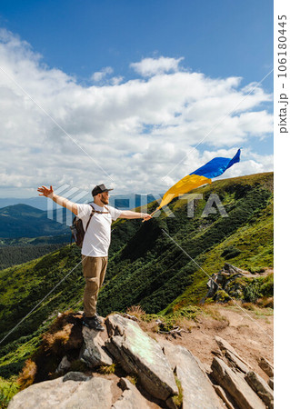 A man on the mountains with a ukrainian flag A man on the mountains with a ukrainian flag 106180445