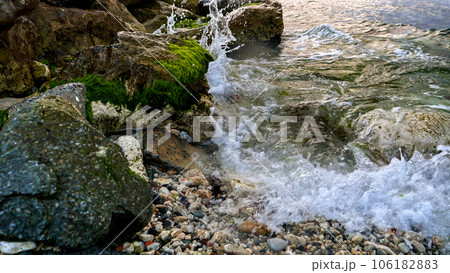 Sea waves gently breaking on the rocky beach, adorned with the flourishing seaweeds and algae. Sea waves gently breaking on the rocky beach, adorned with the flourishing seaweeds and algae. 106182883