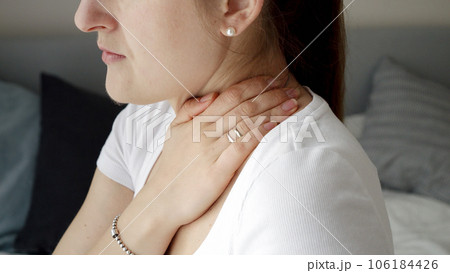 Closeup of young woman massaging her neck feeling pain. Concept of healthcare problems, pain relief and injuries. Closeup of young woman massaging her neck feeling pain. Concept of healthcare problems, pain relief and injuries. 106184426