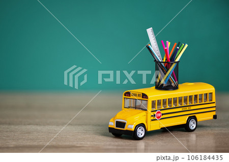 Toy school bus, back to school concept. Creative composition of yellow school bus carrying variety of school supplies. Toy school bus, back to school concept. Creative composition of yellow school bus carrying variety of school supplies. 106184435