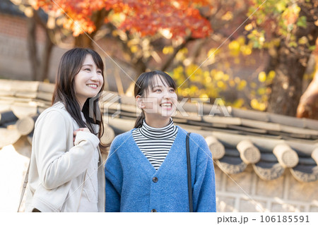 紅葉を見ながら会話をする女性たち 106185591