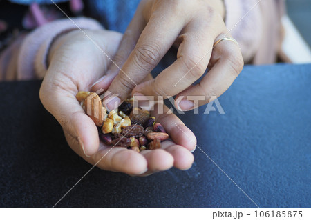 women hand pick many mixed nuts women hand pick many mixed nuts 106185875