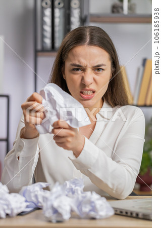 Angry furious woman working at home office throwing crumpled paper, having nervous breakdown at work Angry furious woman working at home office throwing crumpled paper, having nervous breakdown at work 106185938