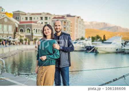 Couple in love tourists enjoying the views of Architecture and luxury yachts in Lustica Bay, Montenegro. Travel around Montenegro concept. Go Everywhere Couple in love tourists enjoying the views of Architecture and luxury yachts in Lustica Bay, Montenegro. Travel around Montenegro concept. Go Everywhere 106186606