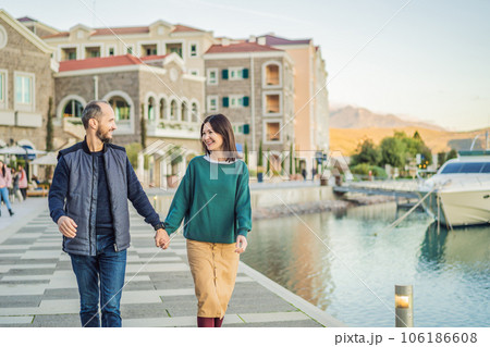 Couple in love tourists enjoying the views of Architecture and luxury yachts in Lustica Bay, Montenegro. Travel around Montenegro concept. Go Everywhere Couple in love tourists enjoying the views of Architecture and luxury yachts in Lustica Bay, Montenegro. Travel around Montenegro concept. Go Everywhere 106186608