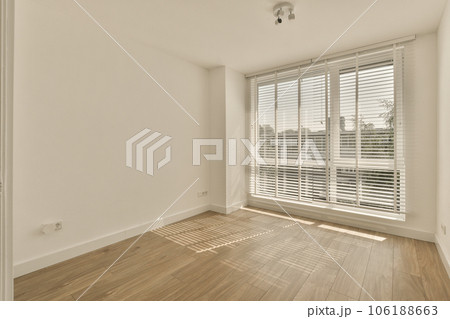 an empty room with wooden floors and white shutters on the windows, looking out onto the cityscapea 106188663