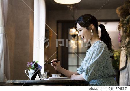 カフェでタブレットを使う若い女性の横顔 106189637