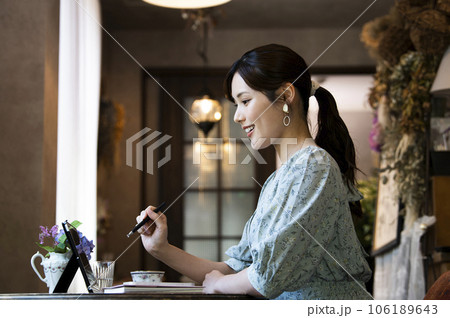 カフェでタブレットを使う若い女性の横顔 カフェでタブレットを使う若い女性の横顔 106189643