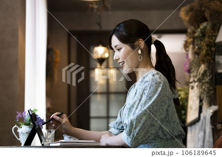 カフェでタブレットを使う若い女性の横顔 106189645
