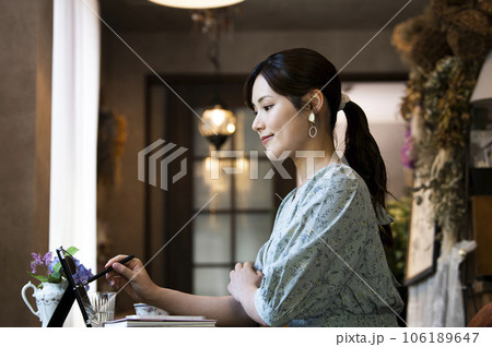 カフェでタブレットを使う若い女性の横顔 106189647