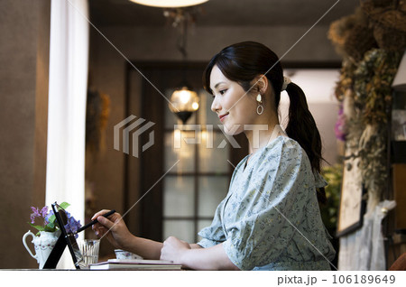 カフェでタブレットを使う若い女性の横顔 106189649