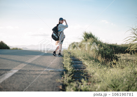 道を歩く女性バックパッカー 106190781