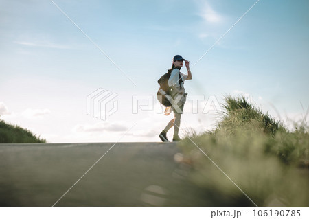 道を歩く女性バックパッカー 106190785