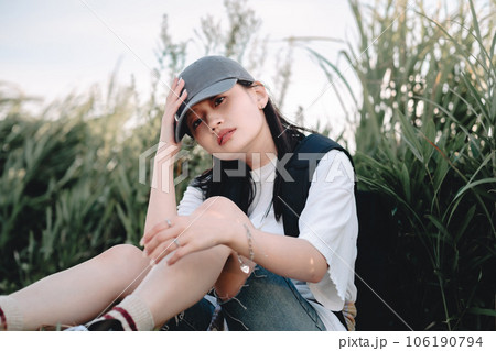 草むらで休憩中のバックパッカーの女性 草むらで休憩中のバックパッカーの女性 106190794