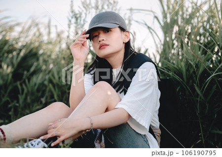 草むらで休憩中のバックパッカーの女性 草むらで休憩中のバックパッカーの女性 106190795