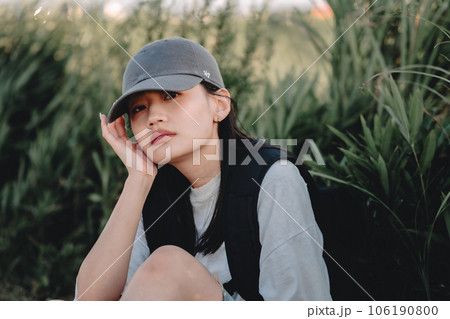 草むらで休憩中のバックパッカーの女性 草むらで休憩中のバックパッカーの女性 106190800
