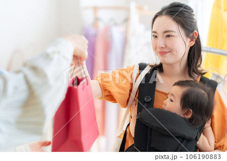 ショッピングモールでショッピングをする赤ちゃんを連れた若いお母さん 106190883