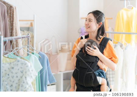 ショッピングモールでショッピングをする赤ちゃんを連れた若いお母さん ショッピングモールでショッピングをする赤ちゃんを連れた若いお母さん 106190893