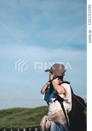 ヒッチハイクをするバックパックを背負った女性 106191086