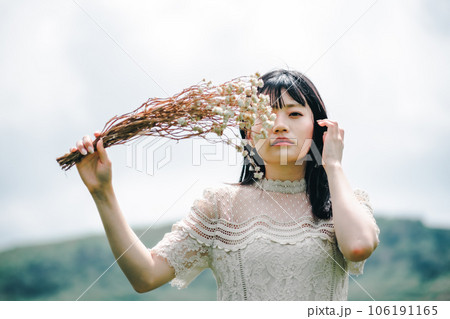 草原でブーケを持ってる女性 106191165