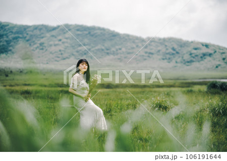 草原の中椅子に腰掛けている女性 106191644