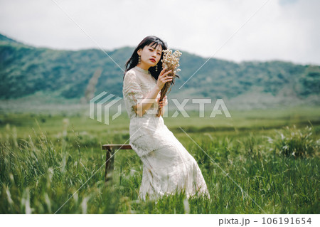 草原の中椅子に腰掛けている女性 106191654
