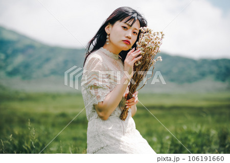 草原の中椅子に腰掛けている女性 草原の中椅子に腰掛けている女性 106191660