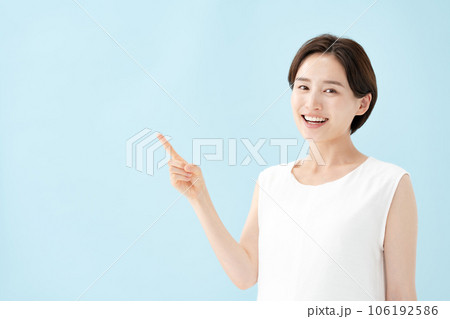女性　指差し　ブルーバック  106192586