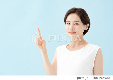 女性　指差し　ブルーバック  106192588