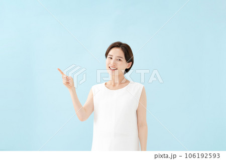女性　指差し　ブルーバック  106192593