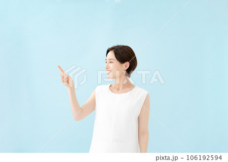 女性　指差し　ブルーバック  106192594
