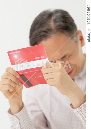 通帳を見て悩む男性 通帳を見て悩む男性 106193664