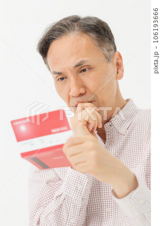 通帳を見て悩む男性 通帳を見て悩む男性 106193666