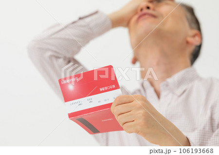 通帳を見て悩む男性 106193668