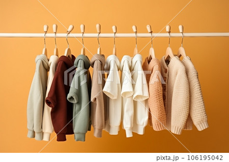 stylish baby clothes hanging on rack against color background stylish baby clothes hanging on rack against color background 106195042