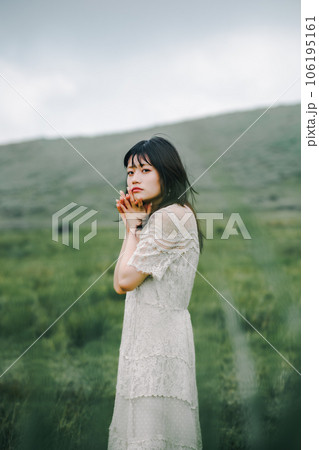 草原と白いワンピースの女性 106195161