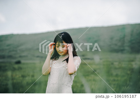 草原と白いワンピースの女性 106195187