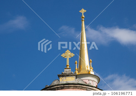 golden spire, golden orthodox cross on gold dome on blue sky. close-up golden spire, golden orthodox cross on gold dome on blue sky. close-up 106196771
